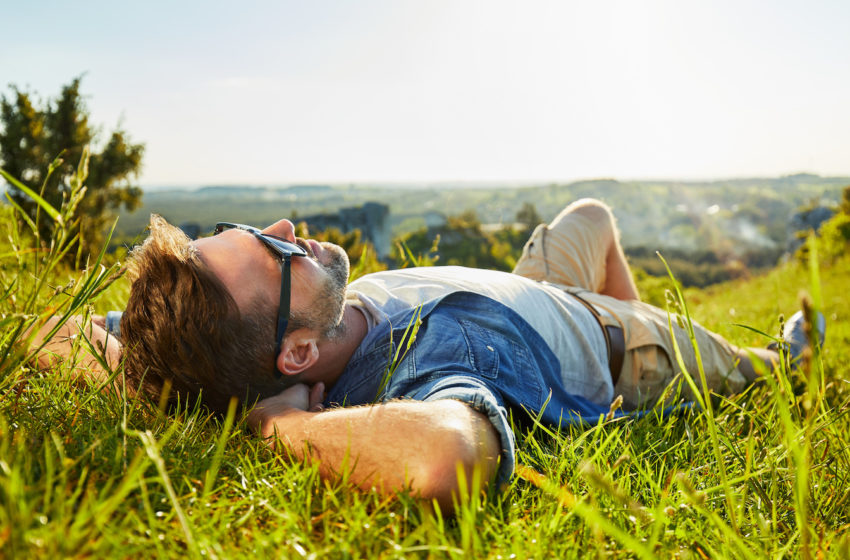 Man lying on grass enjoying peaceful sunny day