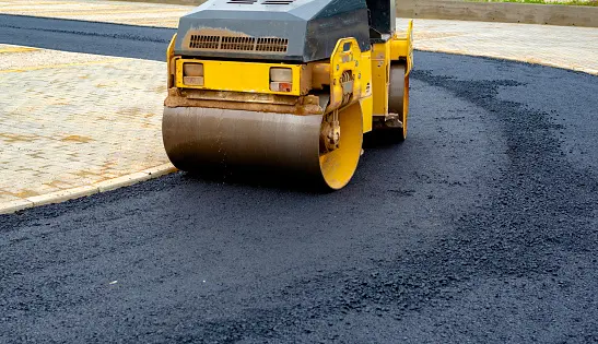 Compact steamroller flatten out the asphalt.