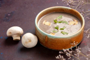 front-close-view-delicious-mushroom-soup-inside-plate-dark-space